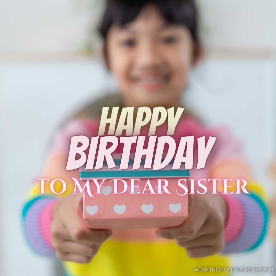 Little Asian girl smiling and excited and holding a red gift box in the living room background. Happ